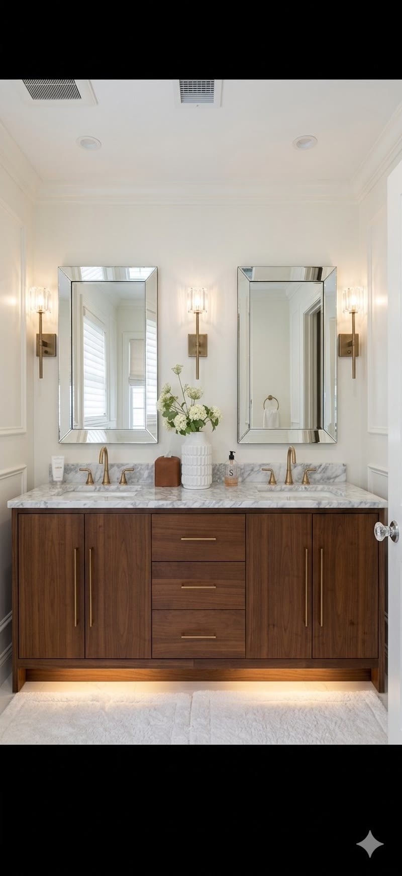 Bathroom renovation with double vanity, marble countertop and brass fixtures